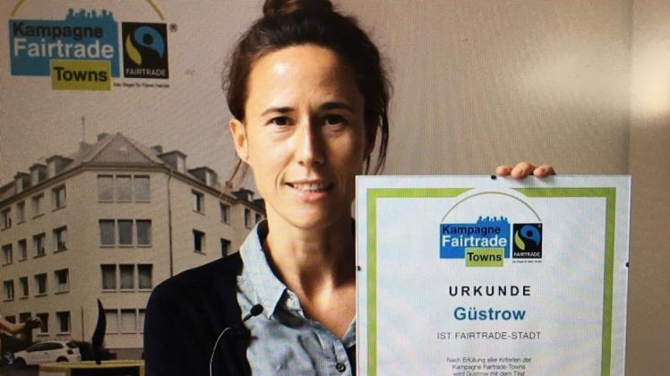 Lisa Herrmann, Kampagnenleiterin bei Trans Fair, mit der Urkunde, die Güstrow zur Fair-Trade-Stadt macht.