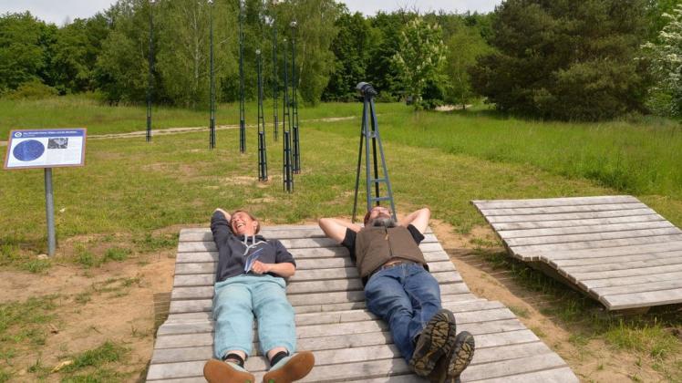 Die Sternenguckerliegen eignen sich auch für ein Sonnenbad: Projektleiterin Marina Kahrmann und Naturparkchef Ralf Koch beim Probeliegen auf dem Sternenbeobachtungsplatz Hellberg bei Goldberg.