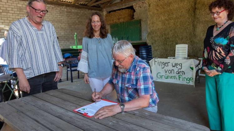 Herbert Zucchi war der erste, der sich in die Unterschriftenliste für den Erhalt der Grünen Finger eintrug – beobachtet von Andreas Peters, Carolin Kunz von der Bürgerinitiative naturnaher Schinkel und Marita Thöle.