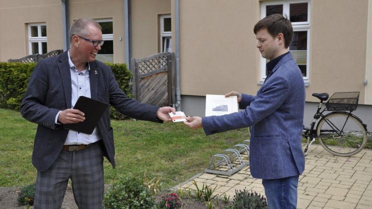 Neuruppins Bürgermeister Nico Ruhle (rechts) überreicht Urkunde und Plakette an GWG-Geschäftsführer Ronald Otto.