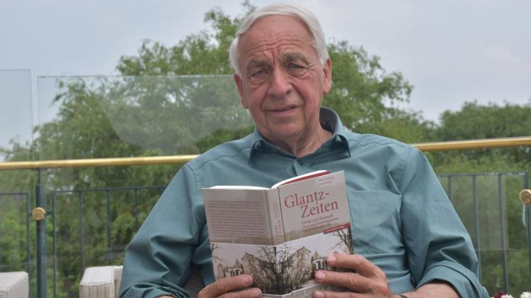 Hat es sich auf seiner Terrasse in Delingsdorf bequem gemacht und blättert in dem Buch, das die bewegende Familiengeschichte erzählt. Enno Glantz, Eigentümer des gleichnamigen Erdbeerhofs.