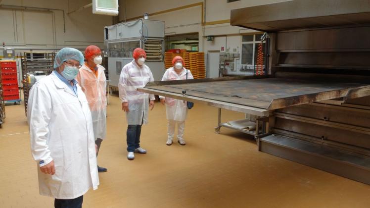 48 Brote finden auf dieser Steinplatte Platz, die dann zum Backen in den Ofen geschoben wird, erklärt Axel Tönjes (links) seinen Gästen Frank Lenk, Carsten Jesußek und Friedchen Weidmüller.