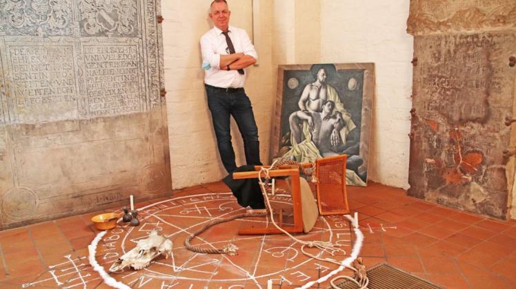 Stefan Thiel inmitten seines Werks „Dämon“, und seinem Öl-Gemälde „Trinitas“.