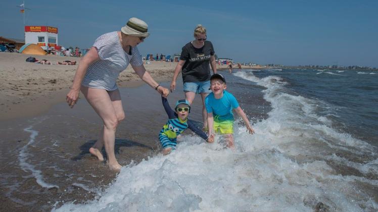 Spaß am Ostseestrand: Oma Elke mit Theo, Hugo und Tochter Birte beim Wellentreten.