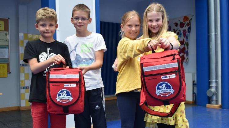 Robert, Tom, Hanna und Pia (v.l.) nehmen die Erste-Hilfe-Rucksäcke für die Grabower Grundschule entgegen.