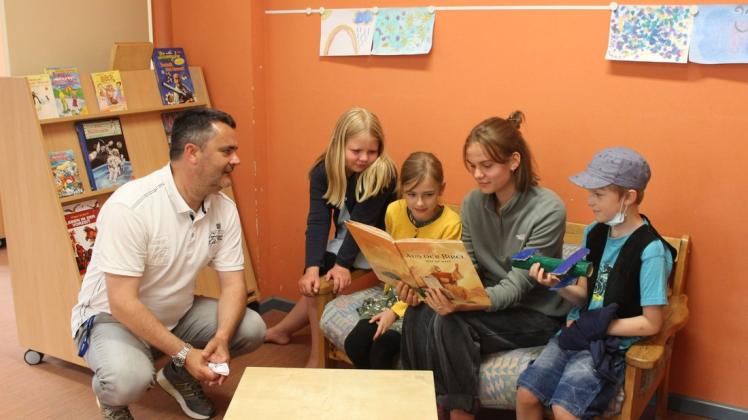 Vorlesen ist nur eine von vielen Aufgaben, die Svea Paulsen während ihres Freiwilligen Sozialen Jahres an der Schweriner Montessori-Schule erledigt. Neben den Kindern hört auch Schulleiter Fred Vorfahr aufmerksam zu.