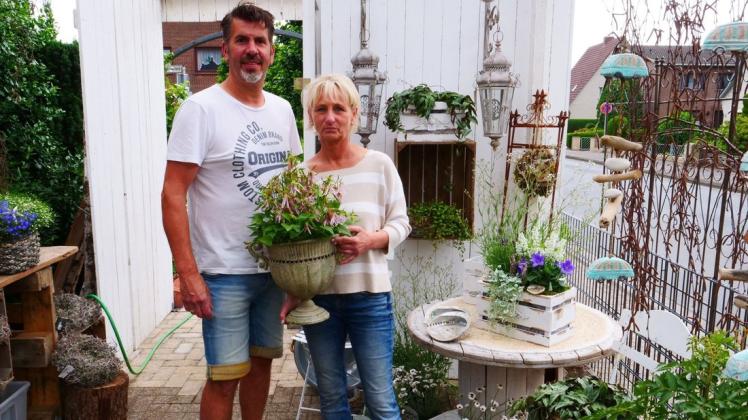 Haben 150 Euro Belohnung ausgesetzt: Susanne und Torsten Harbers vermissen unter anderem Pflanzpokale und Holzkisten, wie sie auch auf dem Foto zu sehen sind.