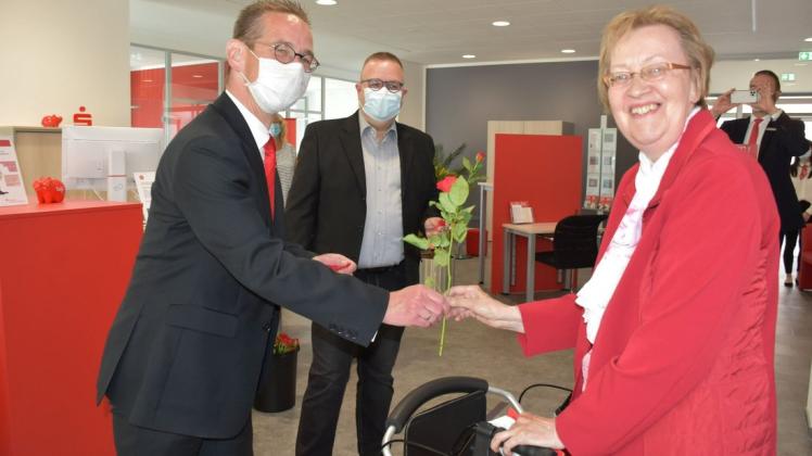 Erste Kundin in der neu eröffneten Geschäftsstelle der Sparkasse in Gadebusch war Karin Voelsch. Die 66-Jährige wurde im Beisein von Bürgermeister Arne Schlien (M.) vom Sparkassenvorstand Kay Facklam mit einer roten Rose begrüßt.