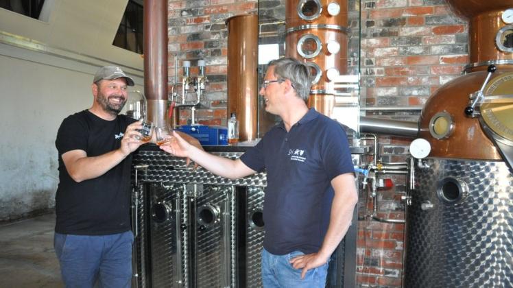 Stoßen mit Föhrer Whisky an: Landwirt Jan Robert Hinrichsen (li.) und der Gast aus Kiel.