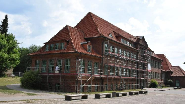 Der Altbau der Kooperativen Gesamtschule Sternberg ist eingerüstet. Maler streichen die Fenster.