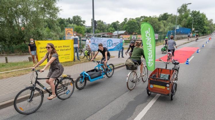 Die Aktivisten vom Radentscheid Rostock und Greenpeace zeigten bei einer Demonstration am Mittwoch, wie Radfahrer am Mühlendamm in beide Richtungen sicher fahren könnten - dafür nahmen sie eine Autospur in Anspruch.