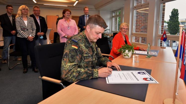 Oberstleutnant Tobias Schmidt und Bürgermeisterin Alice Gerken unterschrieben im Beisein einiger geladener Gäste die Patenschaftsurkunde.