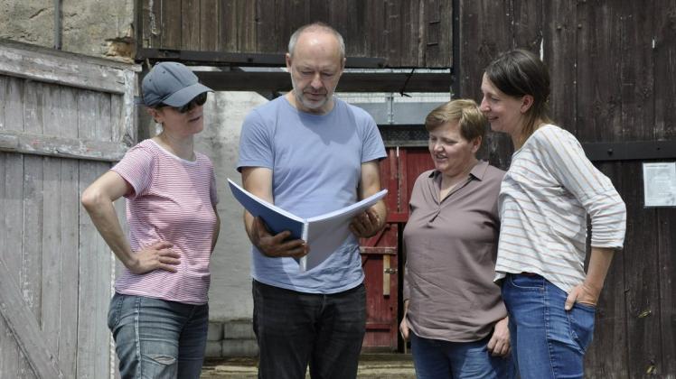 Steffen Tast zeigt Regisseurin Mira Ebert, der Vereinsvorsitzenden Jana Schegel sowie Bühnenbildnerin Karla Fehlenberg (v.l.n.r.) die fertig gewordene Partitur der Märchenoper.
