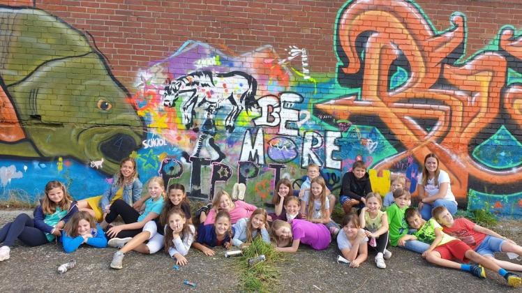 Die vierte Klasse der Christophorusschule hat ein Graffiti im Bohmter Hafen gesprüht. Schulleiterin Nicole Lehnen (Dritte von links) freut sich über das Ergebnis. Alle Beteiligten waren negativ getestet.