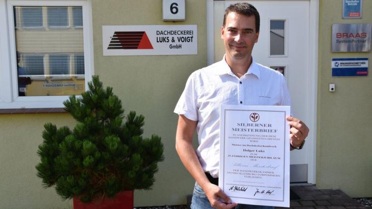 Vor seinem Betrieb zeigt Holger Luks stolz die Ehrenurkunde. Vor seinem Betrieb zeigt Holger Luks stolz die Ehrenurkunde.
