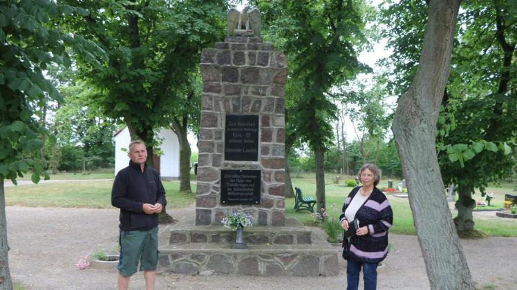 Der aktuelle Ortsvorsteher Carsten Höger und Angelika Schulz, eine seiner Vorgängerinnen, stehen auf dem Laaslicher Friedhof am Denkmal für die im Weltkrieg gefallenen Soldaten.