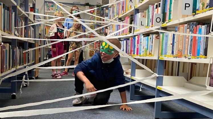 Der neunjährige Liam Alexander kämpft sich durch die Spinnennetze in der Stadtbibliothek.
