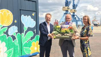 Rostocks Umweltsenator Holger Matthäus (Grüne, l.) nimmt im Stadthafen die Bewerbung als Buga-Außenstandort von Teterows Bürgermeister Andreas Lange (parteilos) und deren Tourismuschefin Jana Koch entgegen.