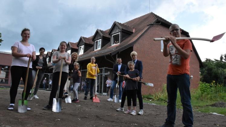 Es kann losgehen: Für das erste Foto von der Baustelle auf dem Schulgelände an der Bleiche nahmen die Kinder schon mal die Spaten in die Hand. Am Donnerstag rücken die Baufahrzeuge an.