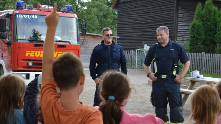 Was eine Feuerwehr so alles macht, erklären Martin Drewes (l.) und Jörg Ellner den Schülern der freien Schule in Bröbberow.