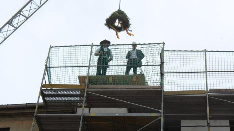 Zimmermann Sebastian Rose (l.) und GWG-Geschäftsführer Ronald Otto beim Richtspruch auf dem Dach des Hauses Großer Markt 11.