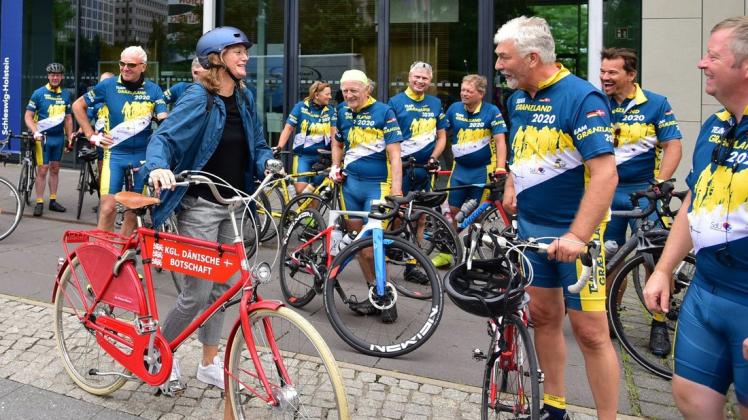 Auch sie ist mit dem Rad gekommen – musste aber nur zwei Kilometer zurücklegen: Dänemarks Botschafterin Susanne Hyldelund begrüßt das Team Grenzland um BDN-Chef Hinrich Jürgensen vor Schleswig-Holsteins Landesvertretung in Berlin.
