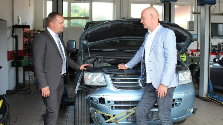 Juniorchef Mario Nix (r.) zeigt Handwerkskammerpräsident Robert Wüst ein Unfallauto in der Werkstatt.