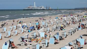 Der Strand in Warnemünde ist in diesem Sommer gut besucht. Für die Tourismusbranche bleibt die Situation weiterhin angespannt.