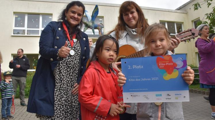 Über die Auszeichnung mit dem 2. Platz als Kita des Jahres 2021 freuen sich Leiterin Mandy Banse (l.), Erzieherin Anja Engels und die Kinder Isabella (l., 4) und Paula (5).