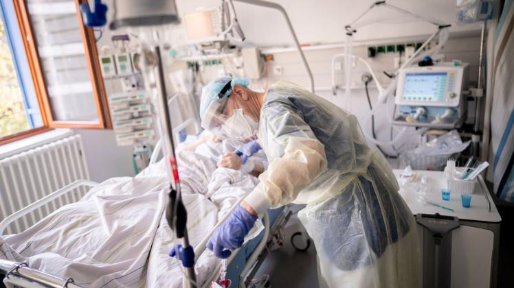 Ein Intensivpfleger arbeitet auf der Intensivstation eines Krankenhauses an einer an Covid-19 erkrankten Patientin.