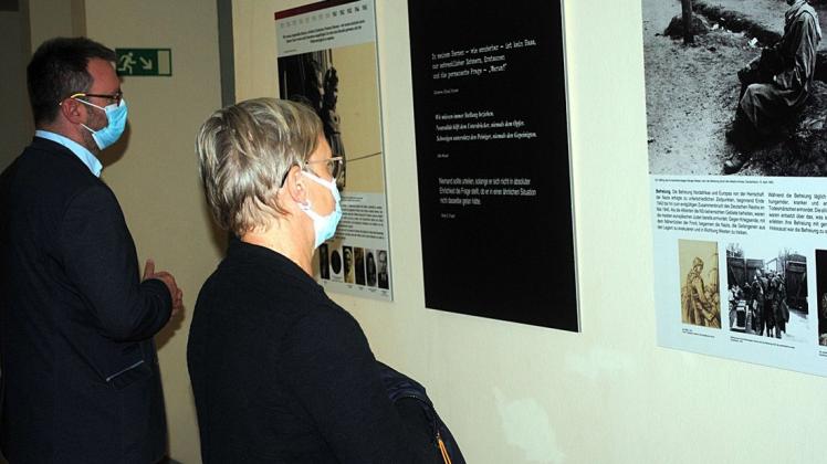 Besucher betrachten die Ausstellung „Shoah – Der Holocaust. Wie war es menschlich möglich?“