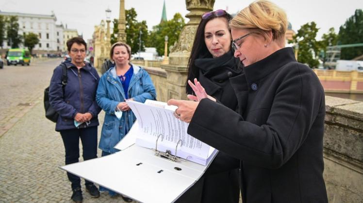 Landtagspräsidentin Birgit Hesse (r.) nimmt die Petition der Spielhallen-Betreiber von Anne Frederich entgegen.
