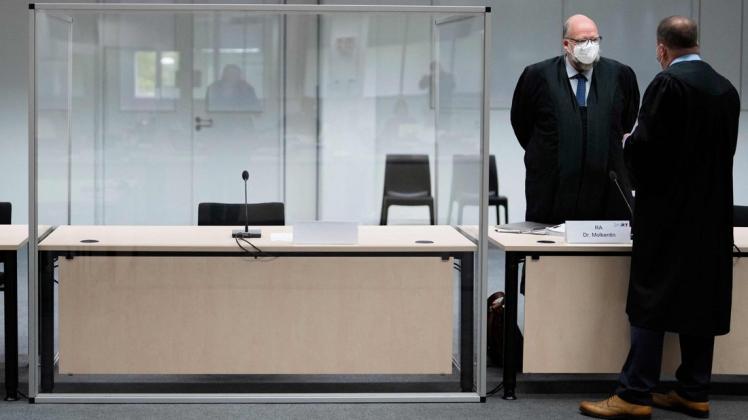 Ein Tisch, ein Mikrophon, ein Sessel und ein corona-konformer transparenter Kasten: Nur die Angeklagte fehlt. Neben dem leergebliebenen Platz steht ihr Anwalt, der Kieler Rechtsanwalt Wolf Molkentin.