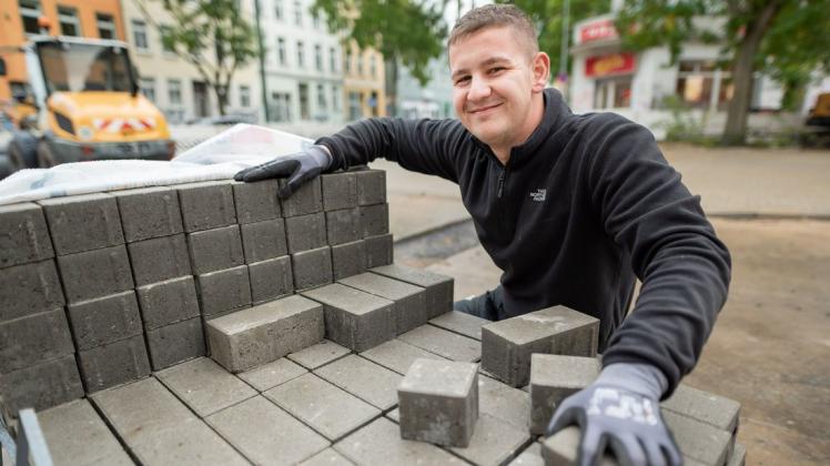 Durch ein Praktikum hat der 21-jährige Max Prüß seine Leidenschaft für das Handwerk Straßenbau entdeckt. Momentan bringt er die Doberaner Straße wieder auf Vordermann.