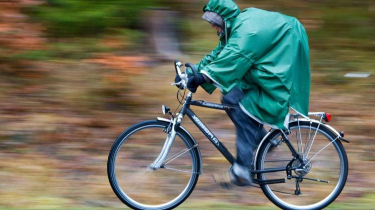 Ein Mann fährt auf seinem Fahrrad durch den Regen.