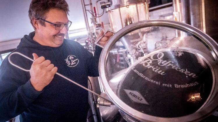 Brauerei-Chef René Krischer nimmt eine Probe aus einem der Kessel.