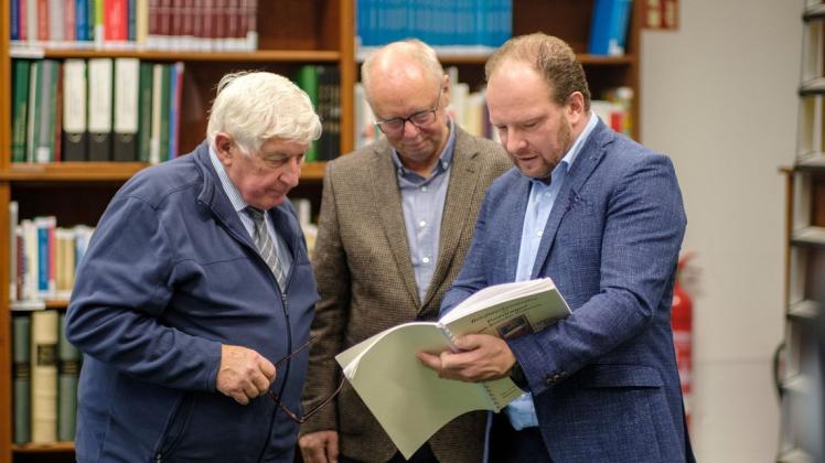 Hansephil-Vorsitzender Gerhard Ehlert, Stadtarchivar Karsten Schröder und Senator Steffen Bockhahn (v. l.) besehen noch einmal das Lebenswerk Manfred Kramers.
