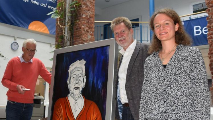 Oberbürgermeister Axel Jahnz, Geschäftsführer Jürgen Beckstette und die Fachbereichsleiterin für Kultur, Eva Fischer (von links), zeigten bei der Bekanntgabe der Namensänderung ein in der Volkshochschule ausgestelltes Porträt von Wilhelm Schroers.