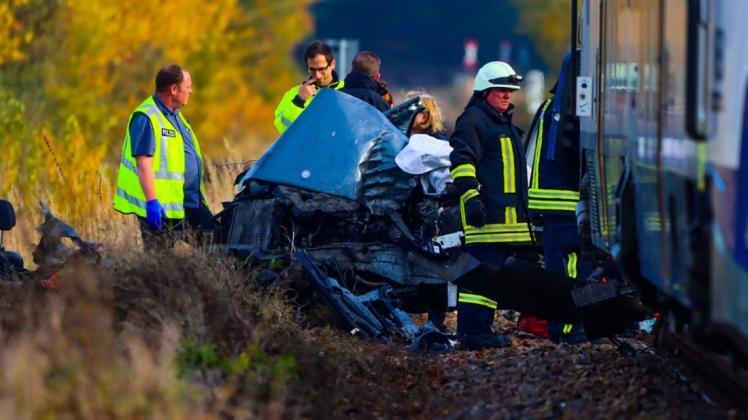 Ein zerstörtes Autos liegt auf den Gleisen vor einem Zug. Bei dem Zusammenstoß zwischen einer Regionalbahn und einem Auto in Brandenburg sind am Samstagmittag zwei Menschen ums Leben gekommen.