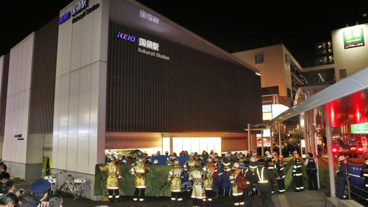 Feuerwehrleute versammeln sich am Bahnhof Kokuryo, nachdem in einem Zug der Keio-Linie ein Feuer ausgebrochen war.