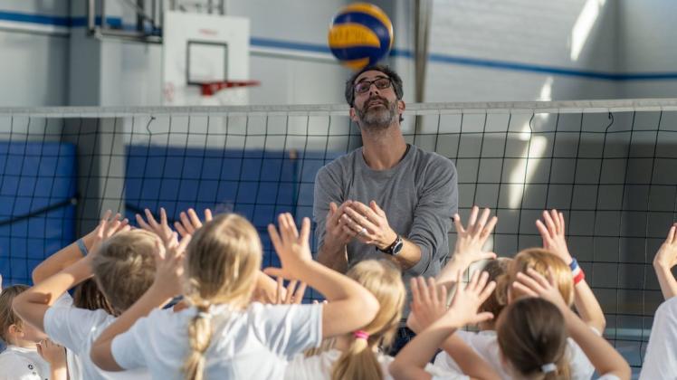 Gemeinsam mit dem ehemaligen Volleyball-Profi Ralph Bergmann trainieren die Kinder die Grundlagen des Volleyballspiels, wie hier das Pritschen.