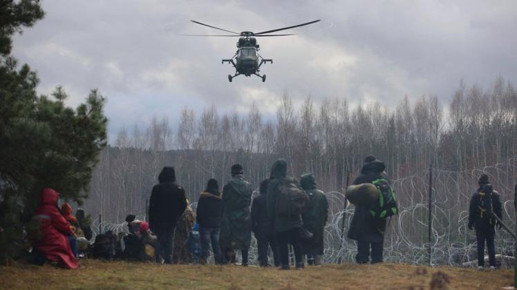 Wie weit eskaliert die Lage noch? Ein polnischer Militärhubschrauber fliegt über eine Gruppe Migranten, die sich an der weißrussisch-polnischen Grenze versammelt haben. Mehrere Hundert Migranten haben sich nach Angaben der Behörden in Belarus zu Fuß auf den Weg zur Grenze zum EU-Nachbarland Polen gemacht.