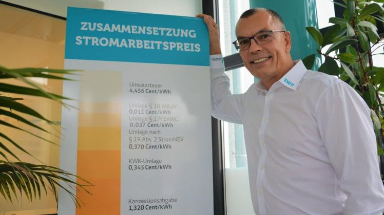 Der Geschäftsführer der Stadtwerke, Dirk Kempke, neben der Säule mit der Zusammensetzung des aktuellen Strompreises.