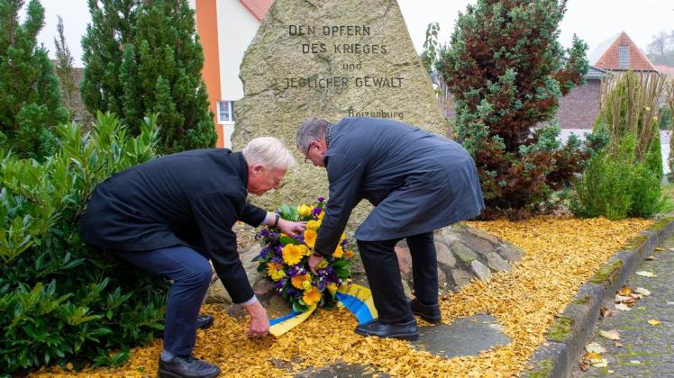 Bürgermeister Harald Jäschke und Stadtvertreter Lutz Heinrich (l.) legen am Volkstrauertag einen Kranz am Gedenkstein auf dem Boizenburger Friedhof nieder.