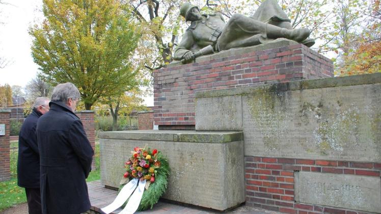 Gedenkminute – nachdem Walter Schulz (links) und Peter Labendowicz den Kranz am Mahnmal im Wilsteraner Stadtpark niedergelegt hatten.