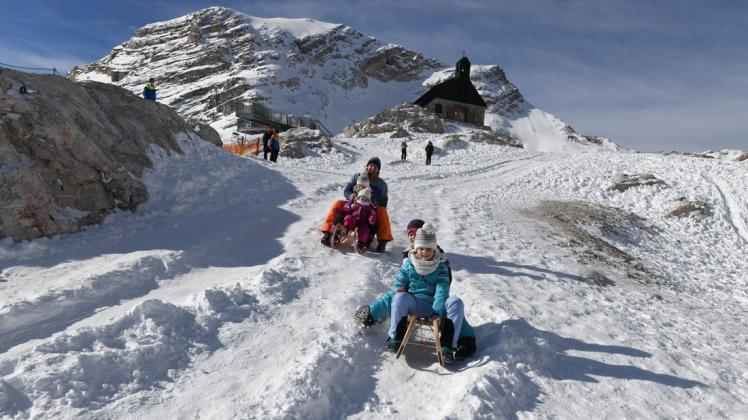 Eine Familie nutz den frischen Schnee am Zugspitzplatt zum rodeln. Deutschlands höchstgelegenes Skigebiet an der Zugspitze will nach einjähriger Corona-Pause als erstes bundesweit am 19. November den Wintersportbetrieb starten.