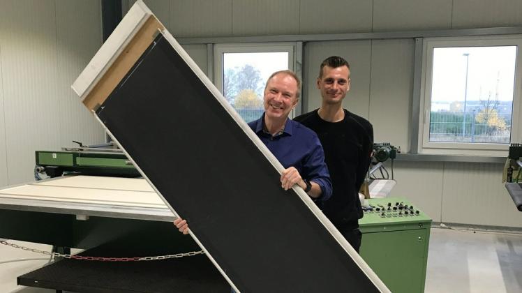 Geschäftsführer Jörg Sinnig und Produktionsleiter Timothy Wulff (r.) präsentieren ein fertiges Heizpaneel.
