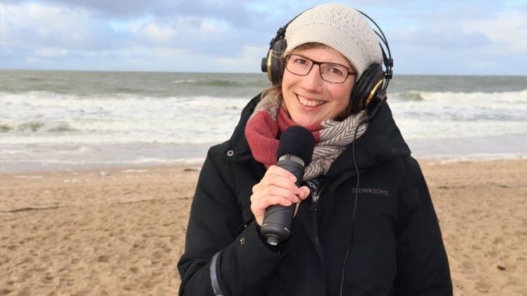 Normalerweise nimmt sie die Podcast-Folgen in Innenräumen aus, aber für shz.de hat sie ihr Equipment zum Strand gebracht: Pia Menning (37).