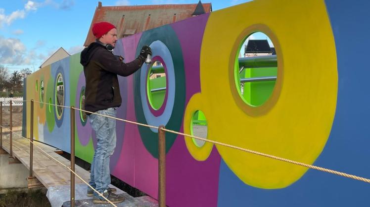 Graffiti-Künstler Carl-Michael Constien besprüht die neue Fußgängerbrücke über den Aalfang in Bützow.