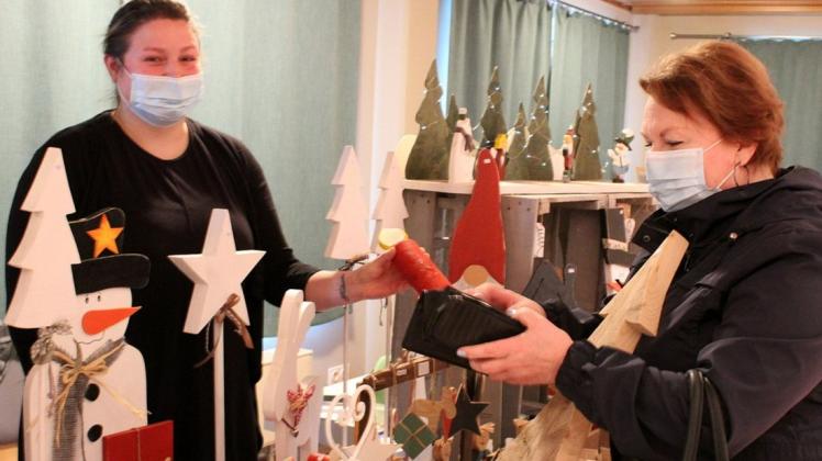 "Der Besuch des Weihnachtsmarktes bringt einen doch mehr in Stimmung",  fand Corinna Stuwe (rechts) aus Gadeland. Am Stand von Eileen Kraft erstand sie hölzerne Dekorationsobjekte.